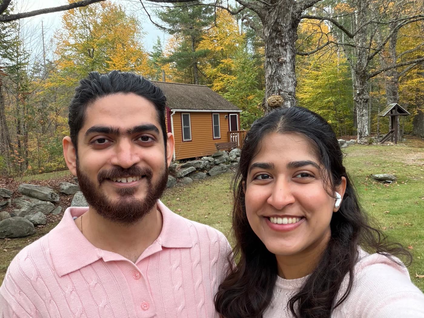 Abirami and Prateek outside a cabin on an autumn afternoon