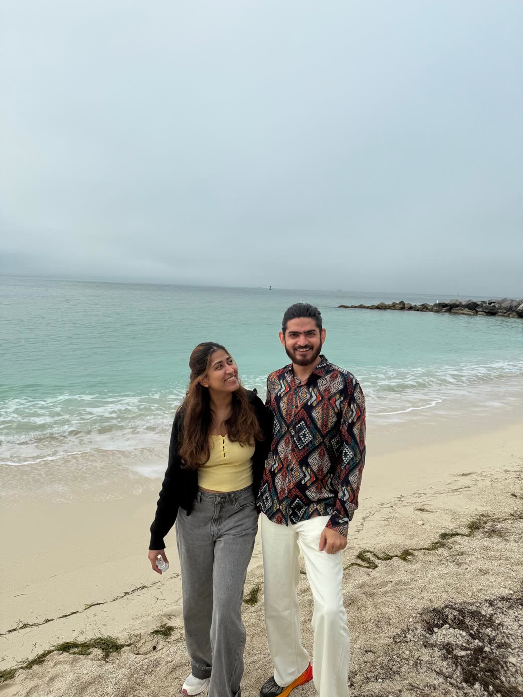Abirami and Prateek on a turquoise beach